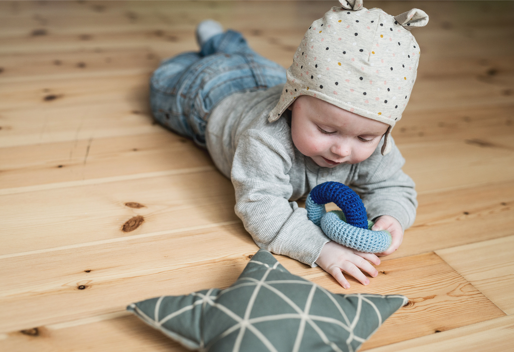 Toddler wearing Earflap hat beanie in sand with dots